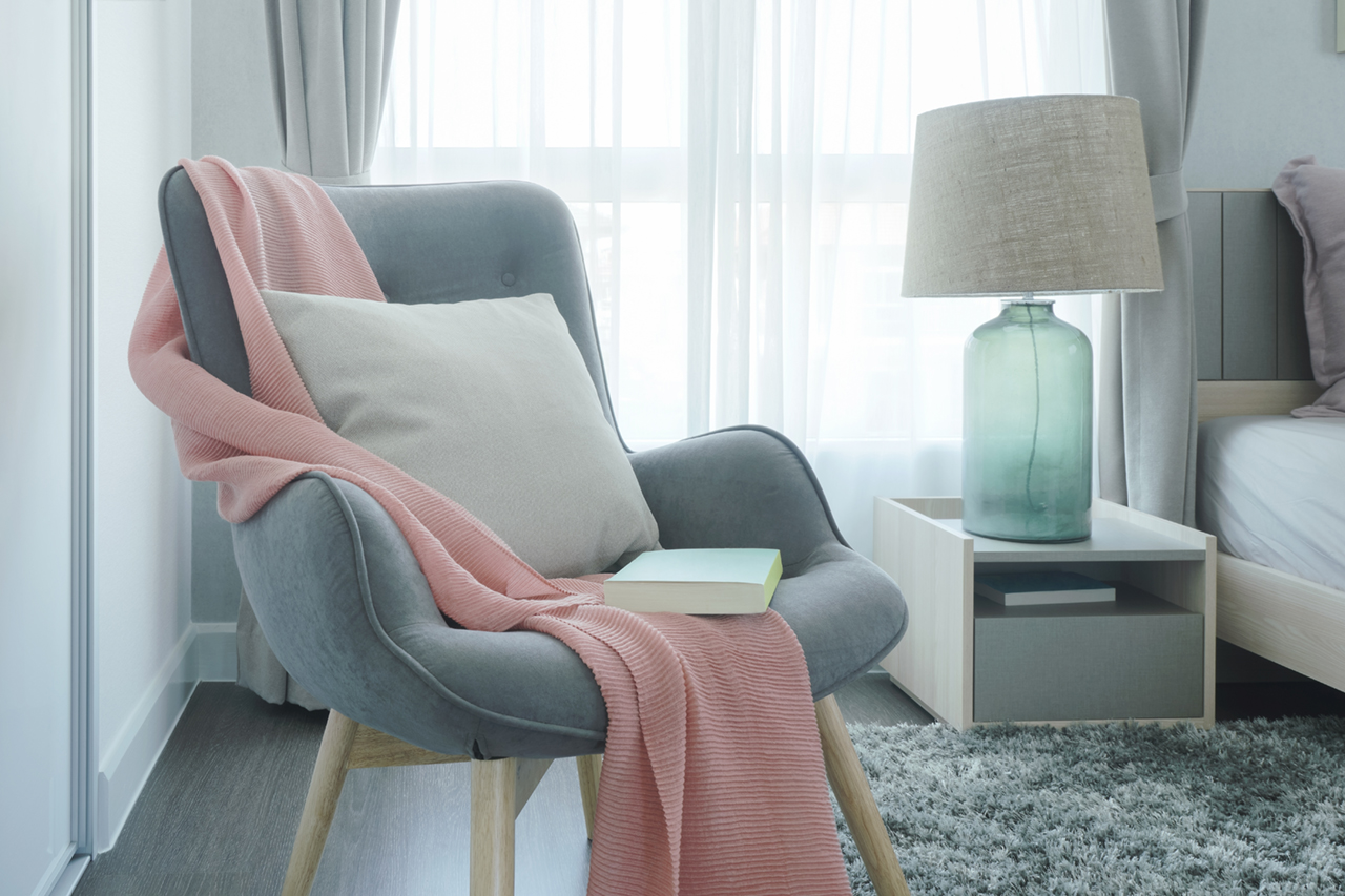 Gray easy armchair with pink scarf